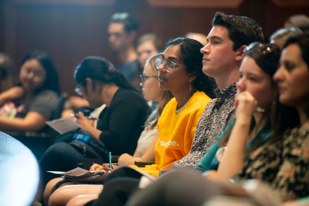 Students in an audience listening to a speaker